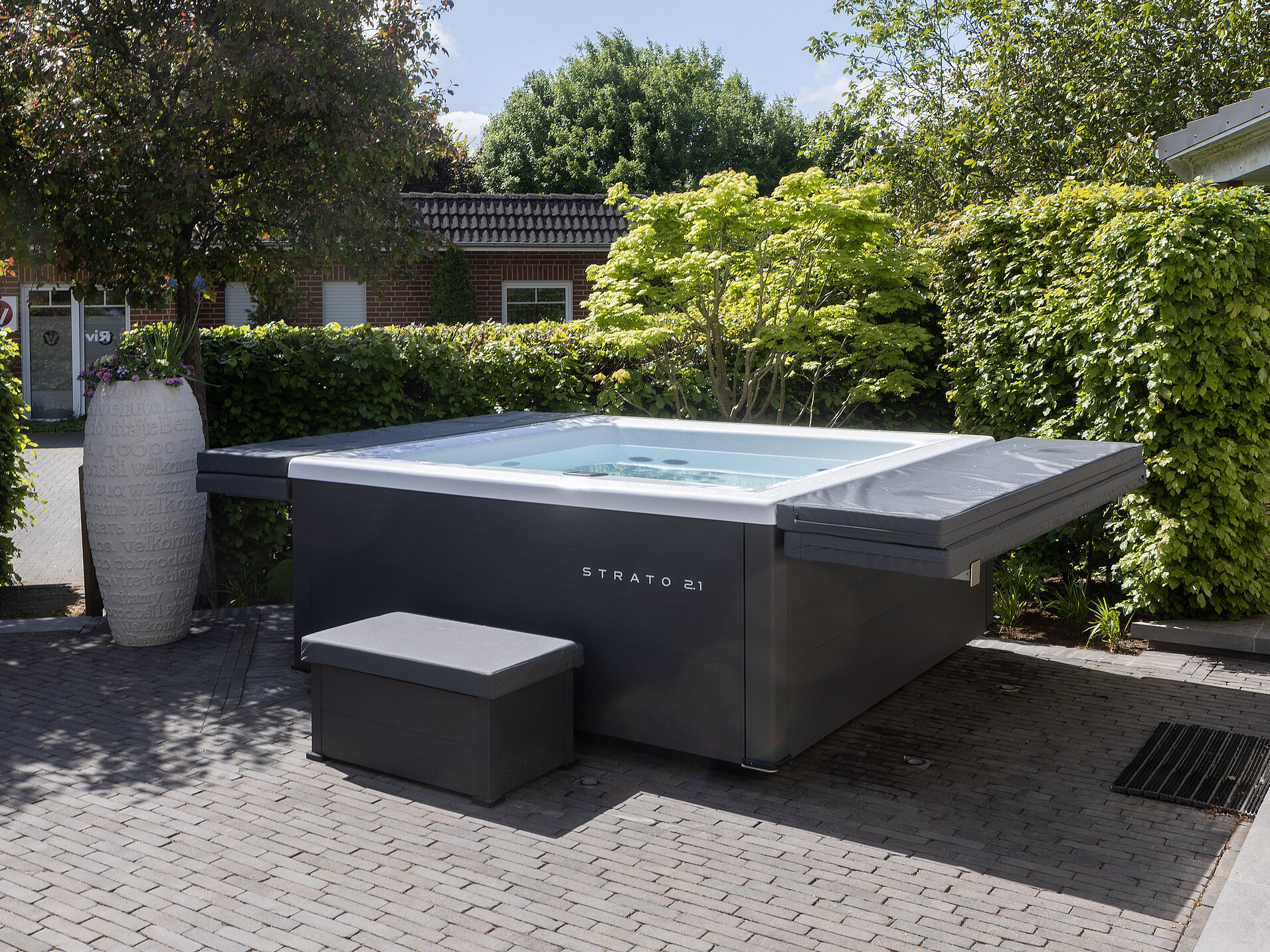Strato 2.1 Spa mit Sitzbank und Abdeckung, inszeniert im Schaugarten der RivieraPool Ausstellung Bremen